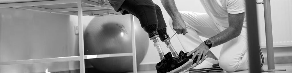 Protetyk reguluje stopę protetyczną w protezie kończyny dolnej u dziecka podczas serwisu technicznego w gabinecie.